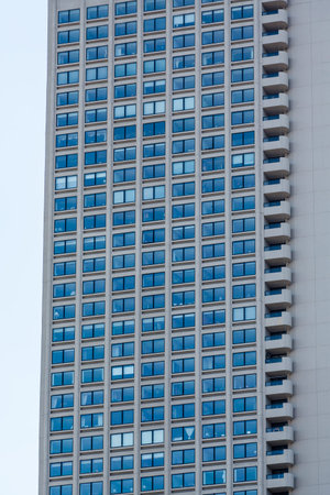 A classic grey stone office tower with many windows