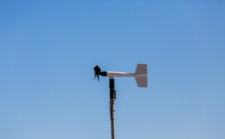 A black and white wind meter on a blue skyの写真素材