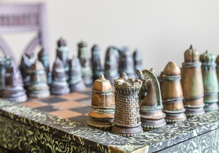 A nice, custom chess set on a table in window lightの写真素材