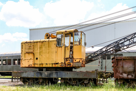 An old yellow crane abandoned in a freight yardの写真素材
