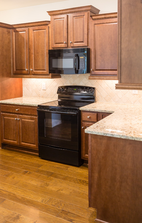 New kitchen with modern appliances and hardwood floorsの写真素材