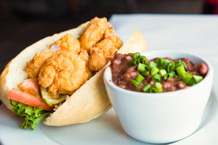 A fresh shrimp po-boy sandwich with a bowl of red beans and riceの写真素材