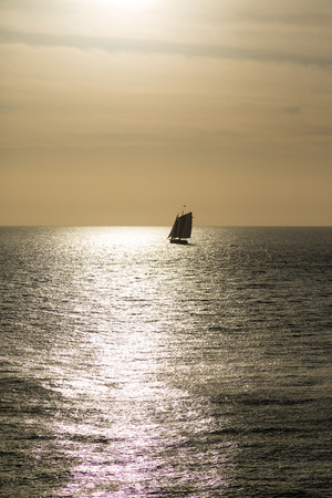 Schooner under sails sailing across a bay under beautiful skiesの写真素材