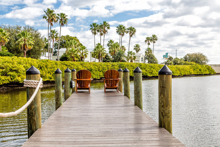 Adirondack chairs on a wooden pier in the tropicsの写真素材