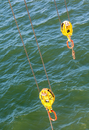 Two Yellow Pulleys Over Green Sea
