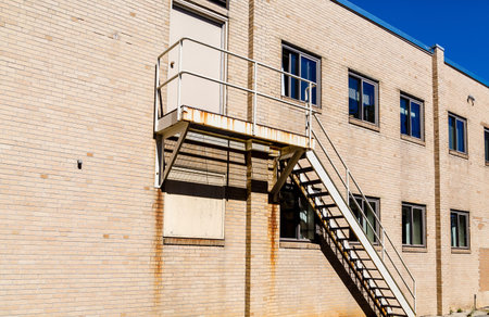 Old rusty staircase down the side of a brick building