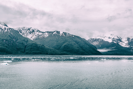 Snowy mountains off the icy waters of Alaskaの写真素材