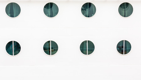 Eight Portholes on White Bulkhead of Cruise Shipの写真素材