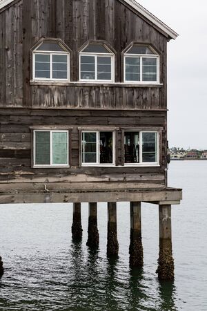 Old Wood Building on Stilts in Water at low tideの写真素材
