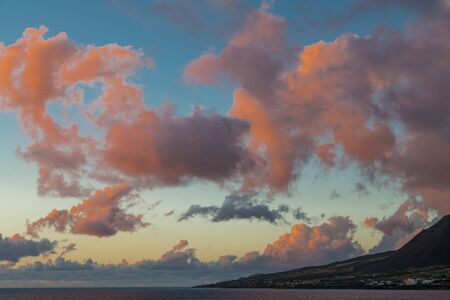 Beautiful evening skies over a green tropical islandの写真素材