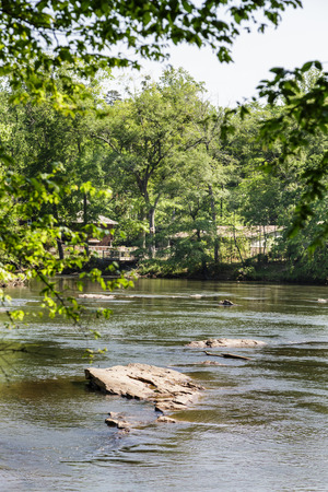 Boulders in Fast River Through Treesの写真素材