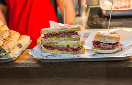 Pastrami and Corned Beef Sandwiches on Lunch Counter with mustard and picklesの写真素材