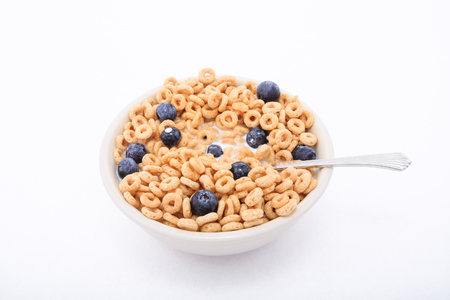 Fresh blueberries on round toasted oat cereal in white bowlの写真素材