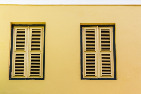 Two Yellow Shutters in Yellow Stucco Wallの写真素材