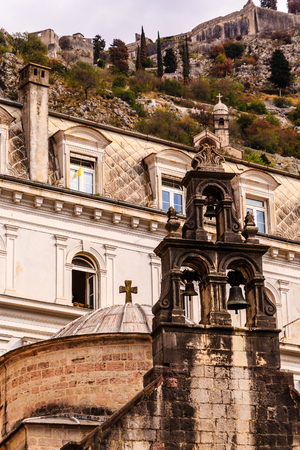 Church Bells with Old Buildings and Mountains in Backgroundの写真素材