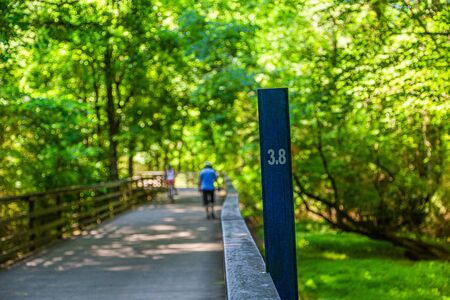 Mile Marker with Walker and Cyclist in Backgroundの写真素材