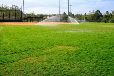 Sprinklers Providing Irrigation on Baseball Field in Early Autumの写真素材
