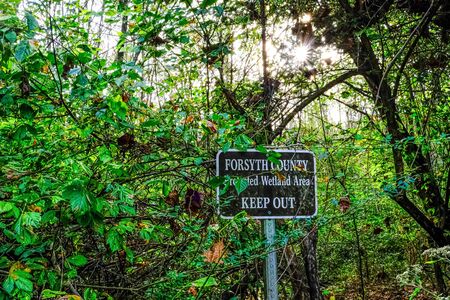 Ominous Keep Out Sign in Wetlands with Sunburstの写真素材