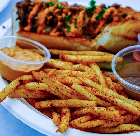 Spicy Fries with Beef Sandwich in Background with Au Jus and Remouladeの写真素材