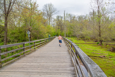 Shirtless Man Running Across Boardwalk
