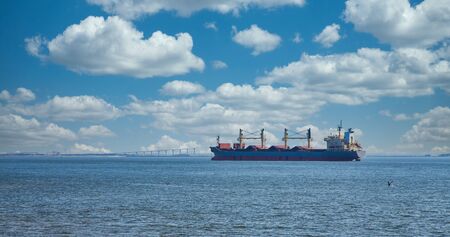 Pelican Diving at Dredging Ship by Bridgeの写真素材
