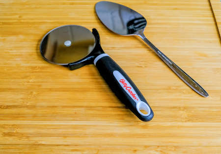 Pizza Wheel and Spatula on Bamboo Cutting Boardのeditorial素材