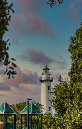 A white brick lighthouse past a public playgroundの写真素材