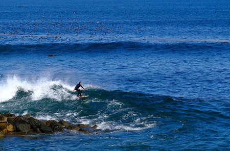 Man Surfing Near Rocksのeditorial素材