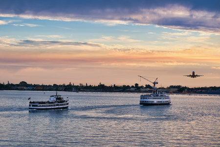 Ferries at Dusk with Plane Taking Off