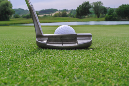 a golf ball and a putter in a beautiful greenの写真素材