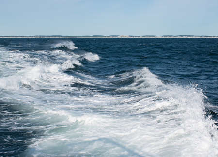 Waves in the water as they are crashing onto each otherの写真素材
