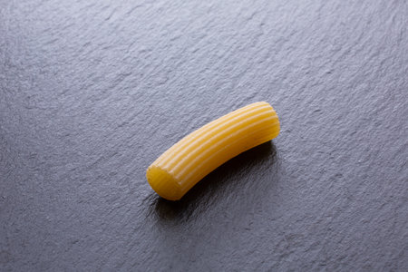 close up of a penne pasta on a black slate background.の写真素材