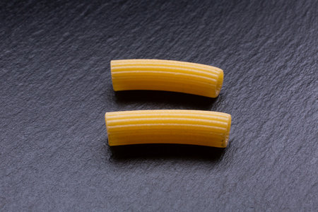 Raw penne pasta on a black slate background. Top view.の写真素材