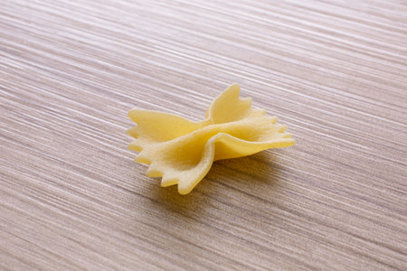 Farfalle pasta on a wooden background. Selective focus.の写真素材