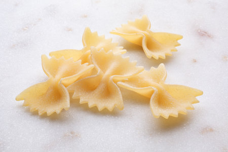 Close up of uncooked farfalle pasta on white background.の写真素材