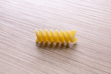 Fusilli pasta on a wooden background. Selective focus.の写真素材