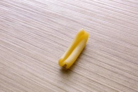 Close up of a raw pasta on a wooden background. Selective focus.