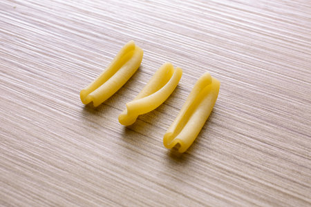 close up of uncooked italian pasta on wooden background with copy spaceの写真素材
