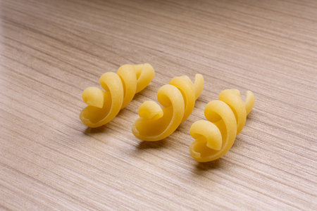 Raw pasta on a wooden background. Dry pasta on the table.の写真素材