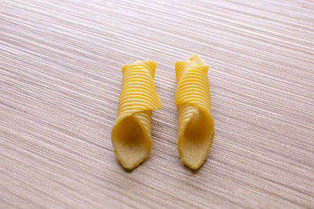 Two pieces of italian pasta on a wooden background. close up.の写真素材