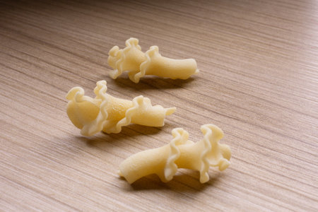 Uncooked macaroni on wooden table, close-up.の写真素材