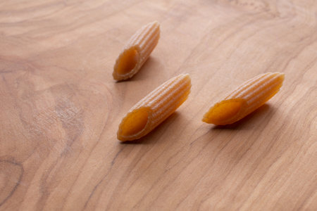 Uncooked italian pasta on a wooden board. Selective focus.の写真素材