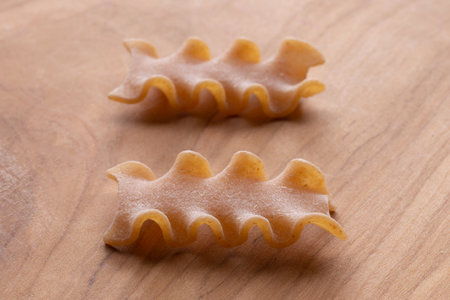 Closeup of two uncooked italian pasta on a wooden boardの写真素材