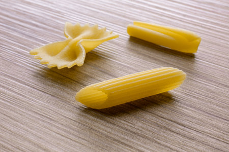 Variety of types and shapes of Italian pasta on a wooden backgroundの写真素材