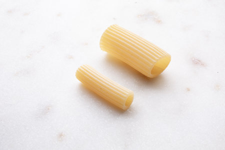 Close up of uncooked italian pasta on white marble background.の写真素材