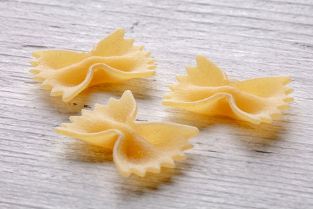 farfalle pasta on a rustic wooden table, closeup of photoの写真素材