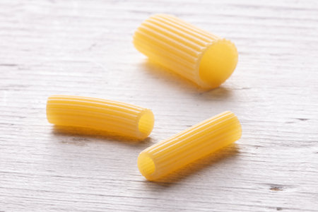 Uncooked Italian pasta on white wooden background. Selective focus.の写真素材