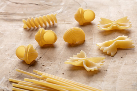 Variety of types and shapes of Italian pasta on a wooden backgroundの写真素材