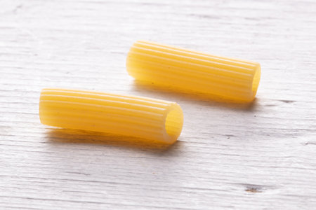 close up of a raw italian penne pasta on wooden backgroundの写真素材