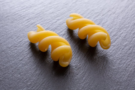 Raw fusilli pasta on a dark background. Selective focus.の写真素材